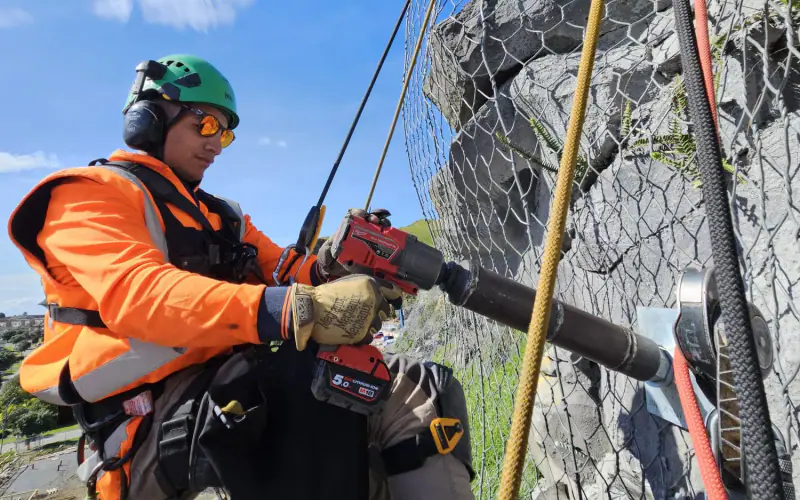 Geo Mana rope-access technician fixing mesh to a steep rock face