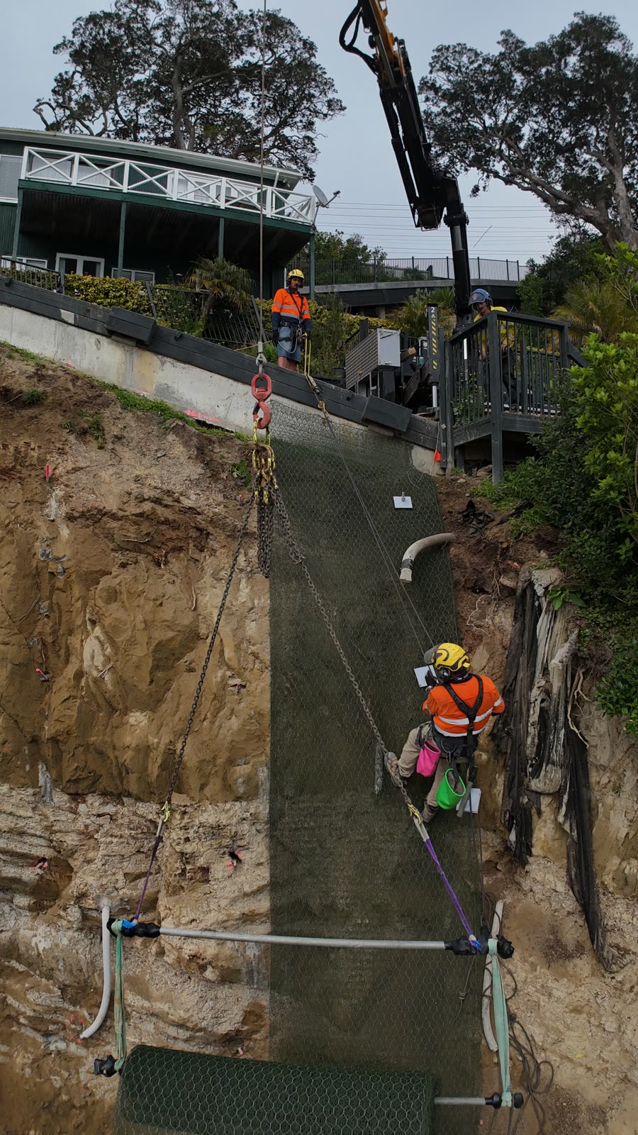 Rope access work across an installed mesh face